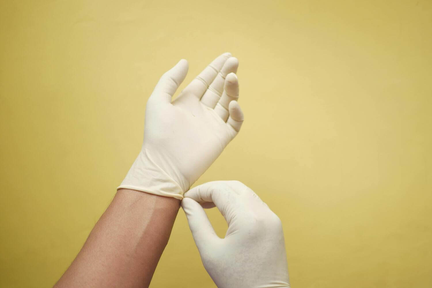 Valged lateksivabad PVC-kindad, mis istuvad tihedalt täpseks tööks laboris ja toitlustuses